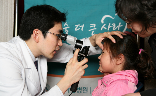 어린이날 맞이 저소득가정 아동 시력검진중인 장면